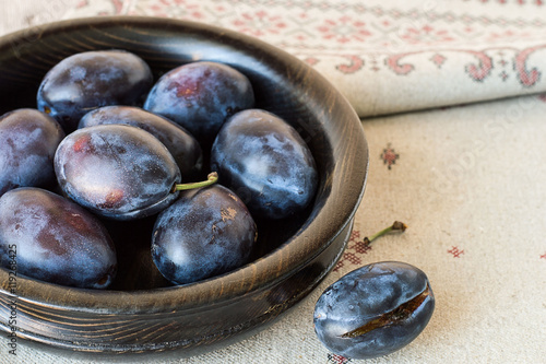 Plums. Plums in a wooden bowl on tablecloths from flax.