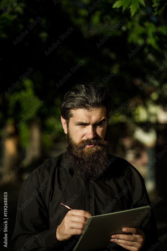 bearded man outdoor with pencil and note bearded man outdoor with pencil and note