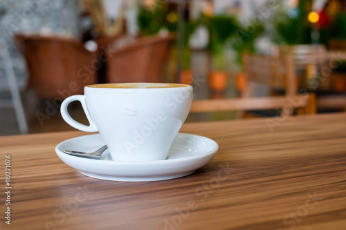 White mug cup of hot coffee on wooden table
