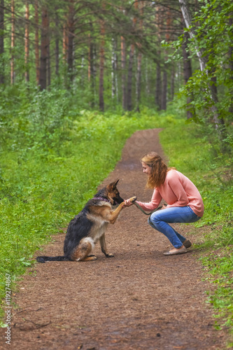 Young woman playing with German shepherd