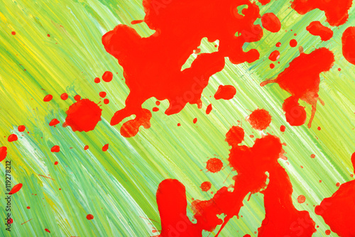 Red splashes of paint on a canvas painted green