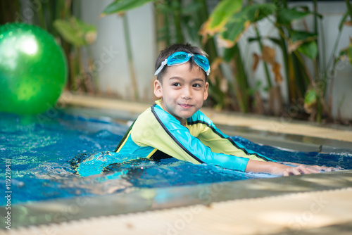 Little mix Asian Arab boy swimming at swimming pool in the hotel outdoor activity photo