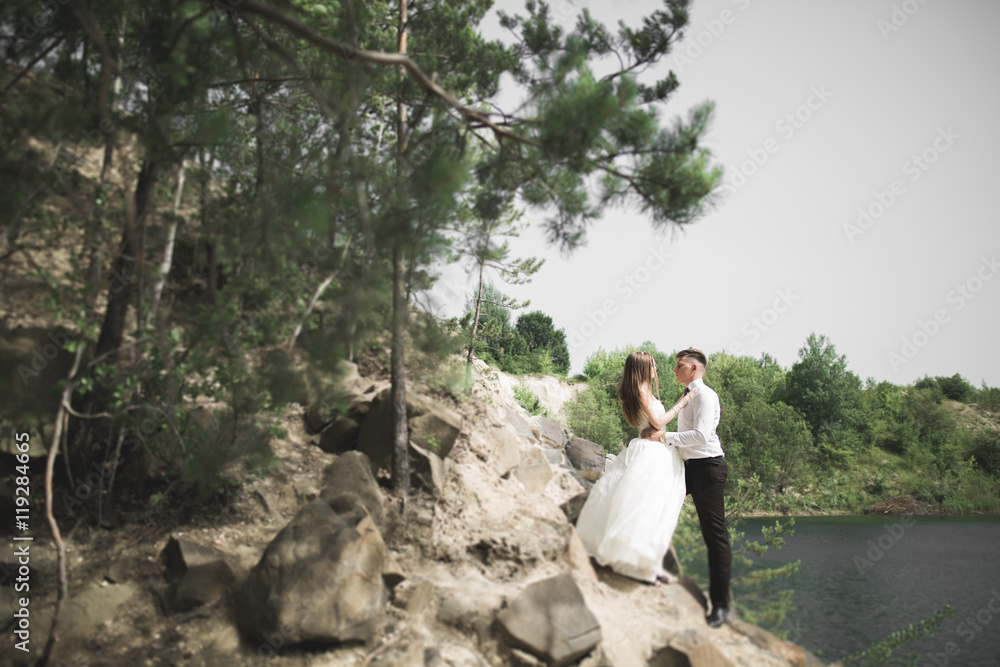 Wedding couple posing on great stones. The bride and groom