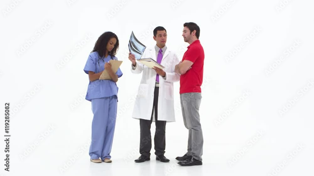 Doctor showing x-rays with patient with nurse taking notes Doctor showing x-rays with patient with nurse taking notes