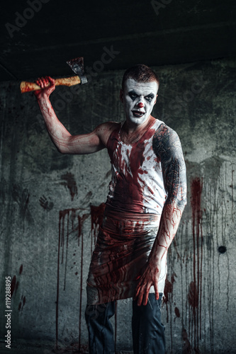 Bloody clown-maniac with ax photo