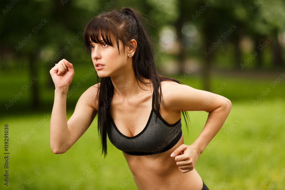 Young sporty brunette woman in sportswear jogging in park Young sporty brunette woman in sportswear jogging in park
