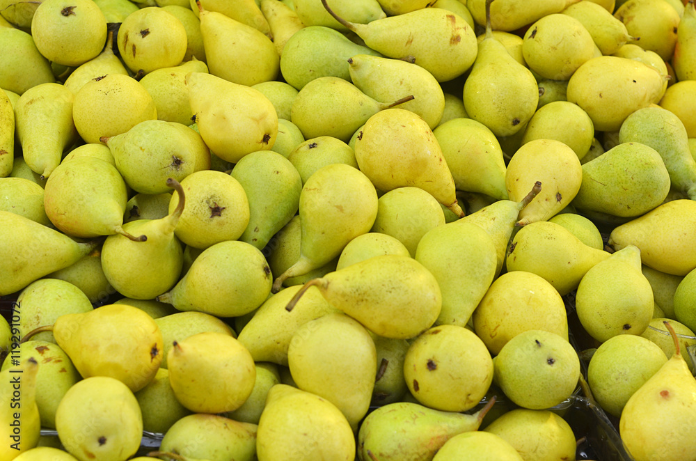 Background with green ripe pears closeup