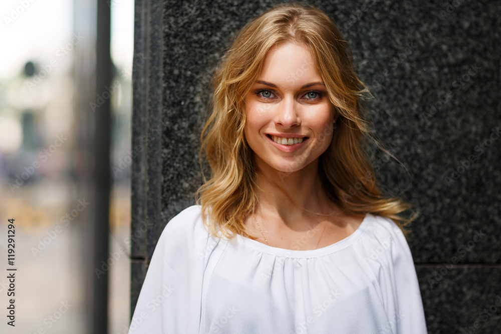 Portrait of cheerful smiling young blond woman looking at camera