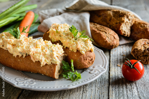 Whole wheat baguette with curd spread  eggs  carrot  green onion  pickled cucumber and mayonnaise