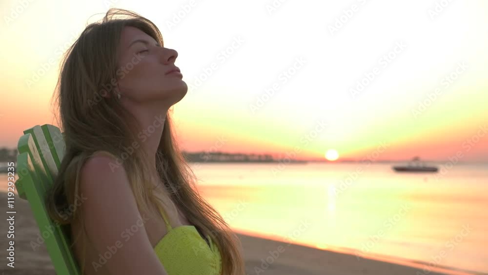 Girl is lying on a deckchair at sunset. HD Girl is lying on a deckchair at sunset. HD