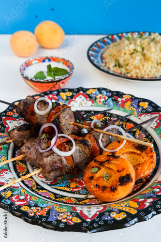 Balti lamb cooked with yoghurt and spices, caramom dried apricots, served boiled bulgur