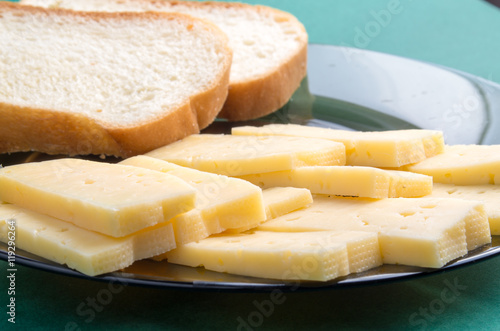 Cut slices of cheese on a plate close-up