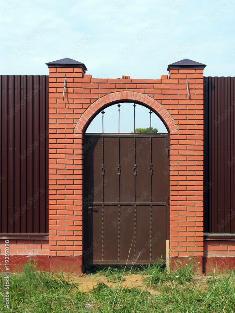 Gate in fence with brick pillars