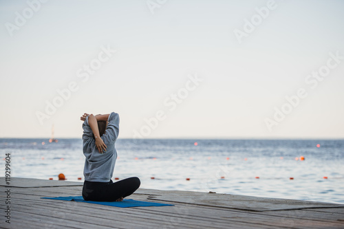 Pretty woman practicing yoga at a lake photo