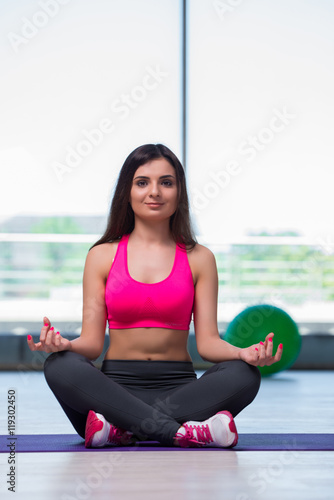 Young woman meditating in gym health concept