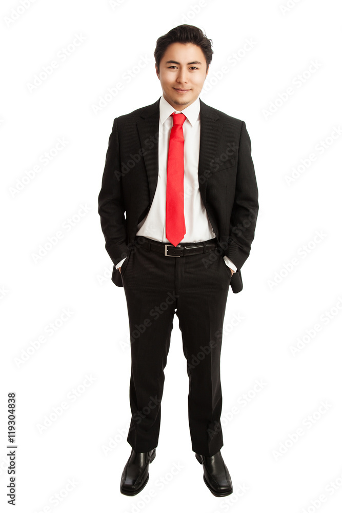 Attractive businessman in a black suit with a red tie looking at camera standing against a white background. Attractive businessman in a black suit with a red tie looking at camera standing against a white background.