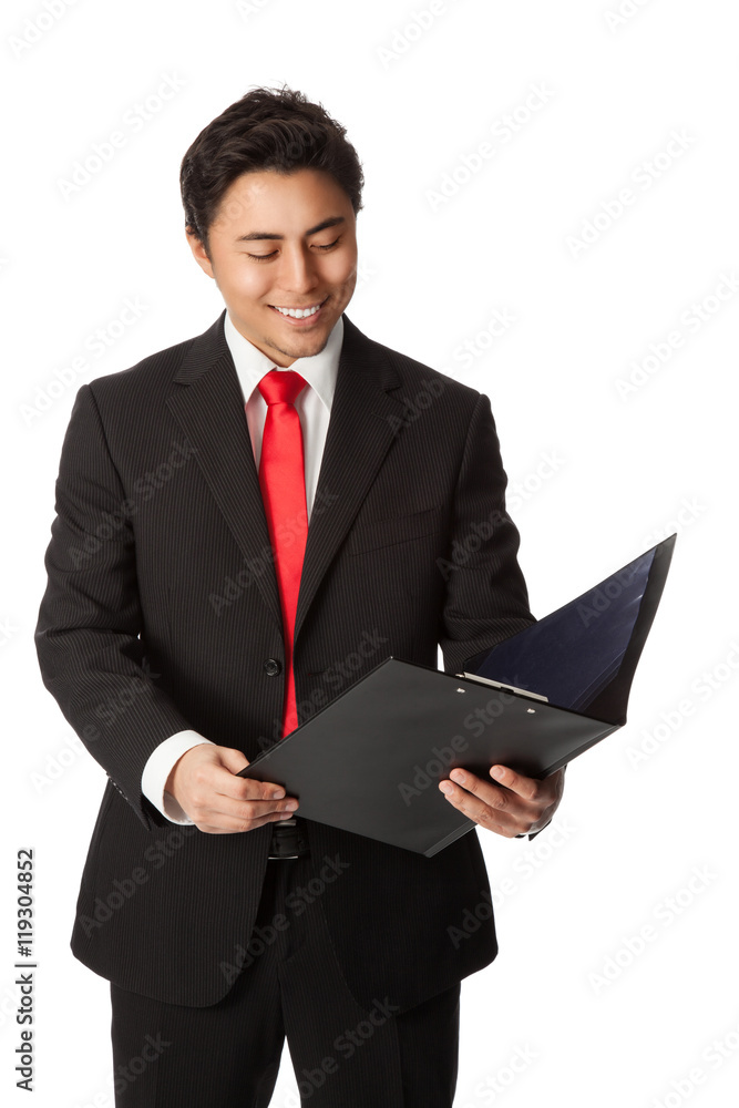 Handsome businessman in a black suit with a red tie, holding a folder reading from a document. White background. Handsome businessman in a black suit with a red tie, holding a folder reading from a document. White background.