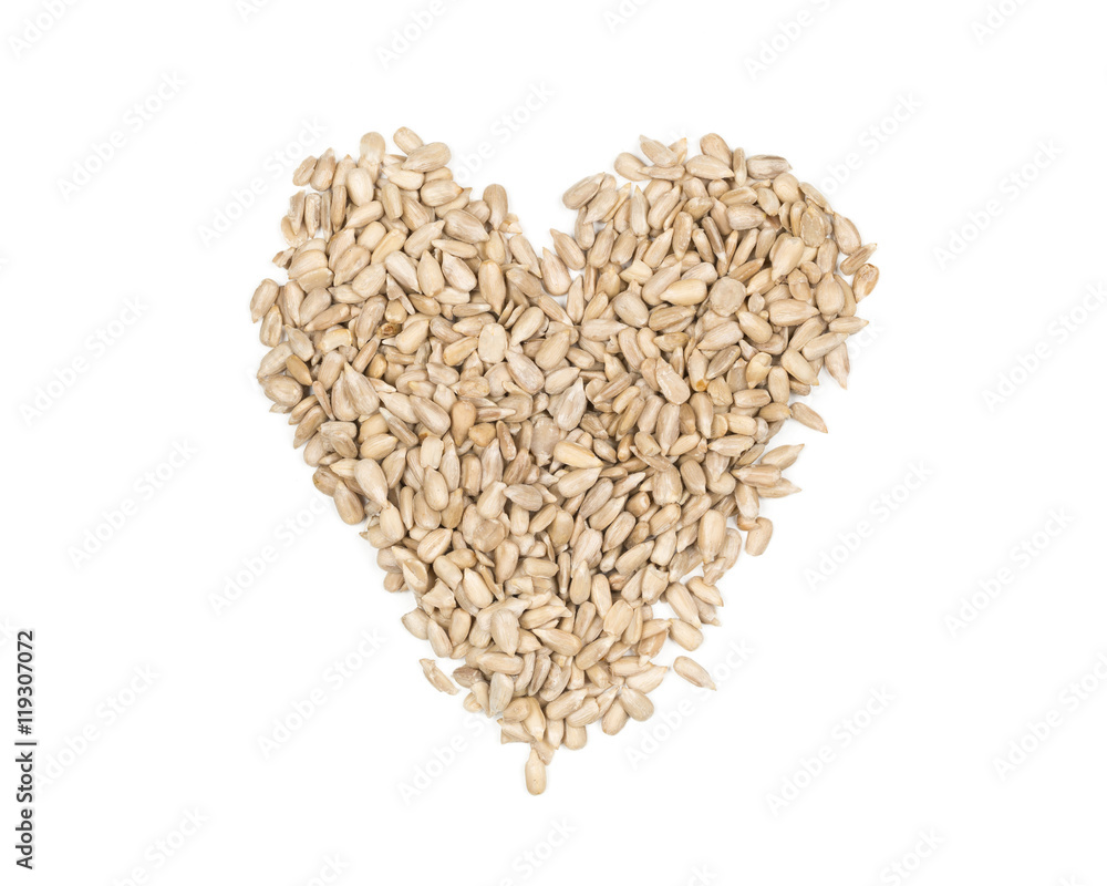 Shelled sunflower seeds heart shaped heap on white Shelled sunflower seeds heart shaped heap on white
