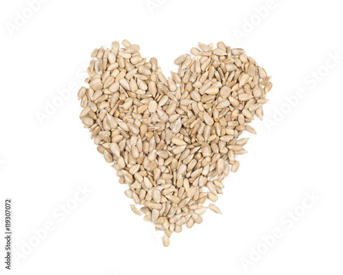 Shelled sunflower seeds heart shaped heap on white