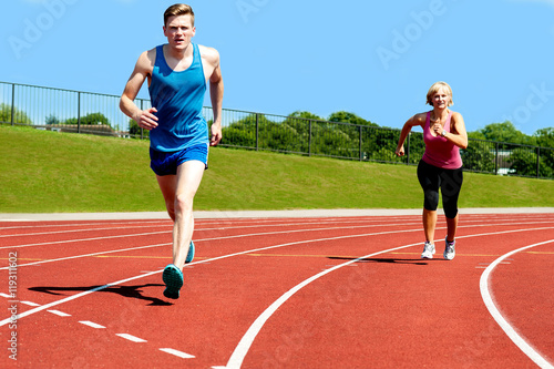 Running race practicing in athletics stadium.