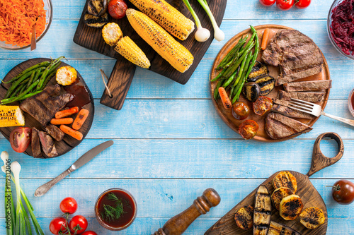 Grilled beef steak with grilled vegetables on wooden blue table
