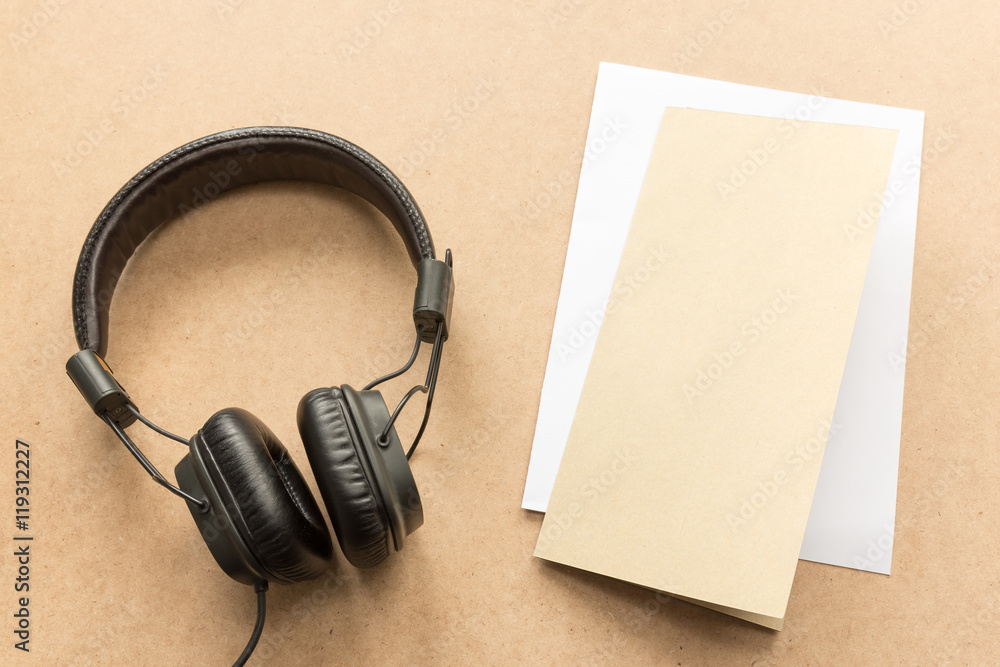 Headphone with brown and white paper note on wood desk in music studio. Headphone with brown and white paper note on wood desk in music studio.