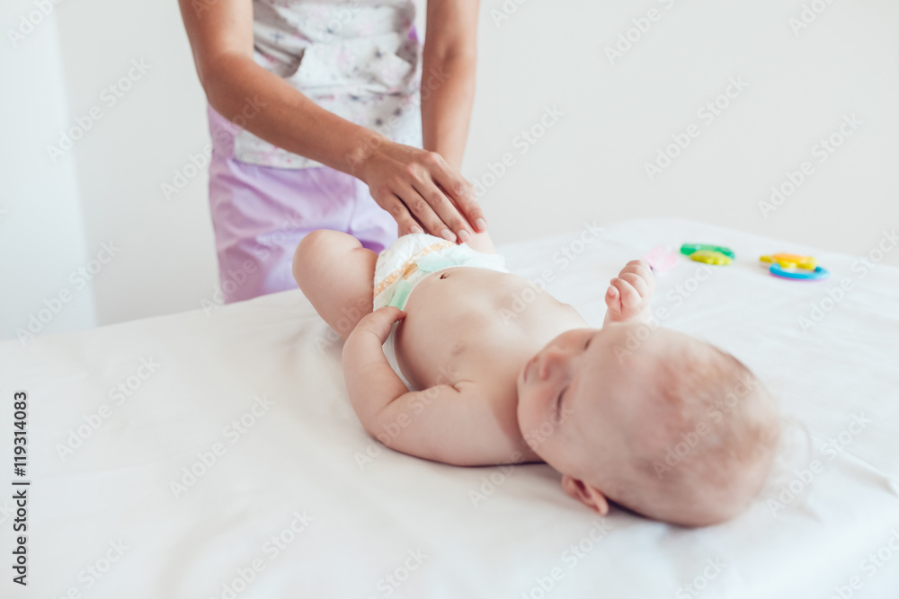 Woman doing exercises and massage the baby Woman doing exercises and massage the baby