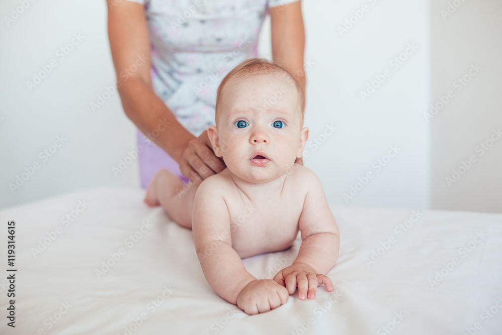 Woman doing exercises and massage the baby Woman doing exercises and massage the baby