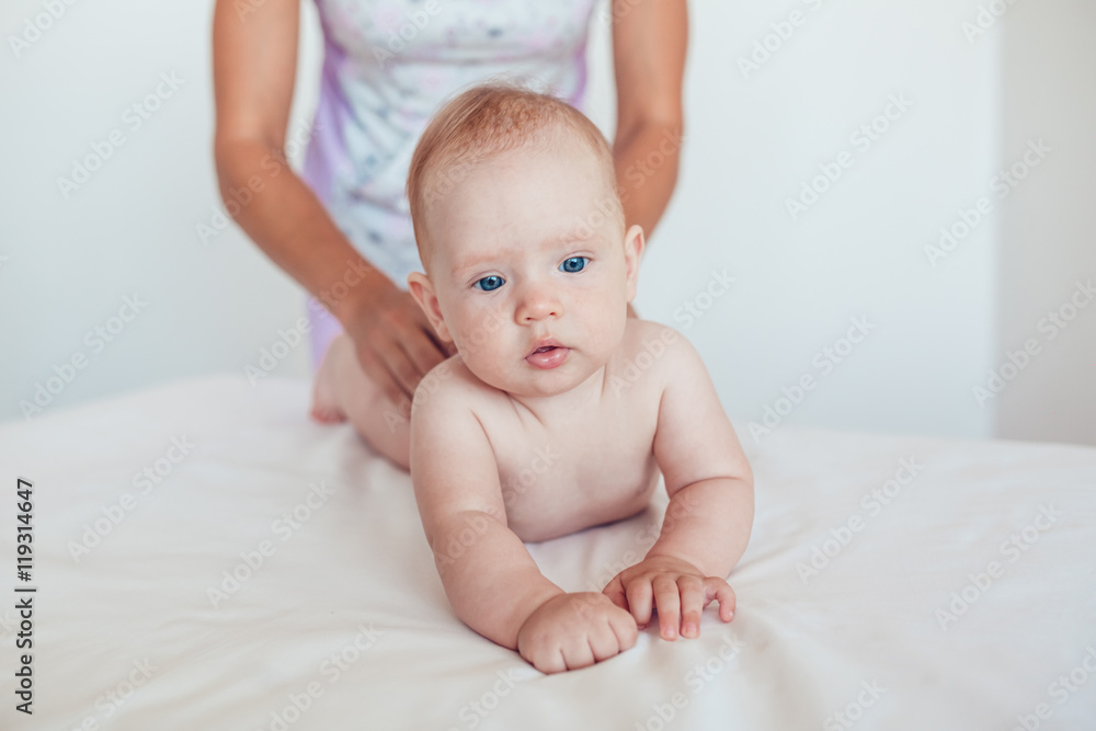 Woman doing exercises and massage the baby Woman doing exercises and massage the baby