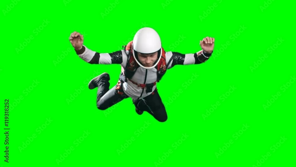 Slow motion video of calm professional skydiver performing free fall, counting meters till parachute opening time and looking at altimeter on his wrist against green background, chroma key Slow motion video of calm professional skydiver performing free fall, counting meters till parachute opening time and looking at altimeter on his wrist against green background, chroma key