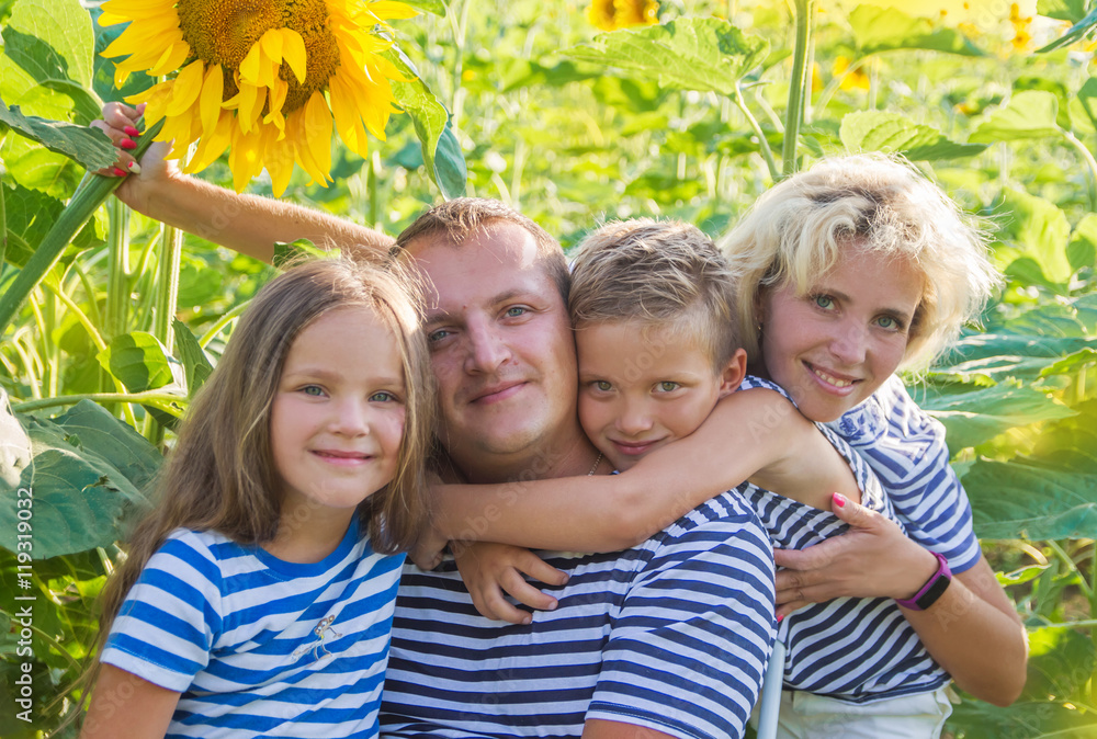 Fototapeta premium Family with two children in sunflower field