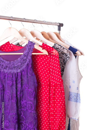 Dresses of different colors on wooden hangers
