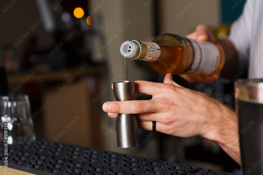 Barman's hands making shot cocktail