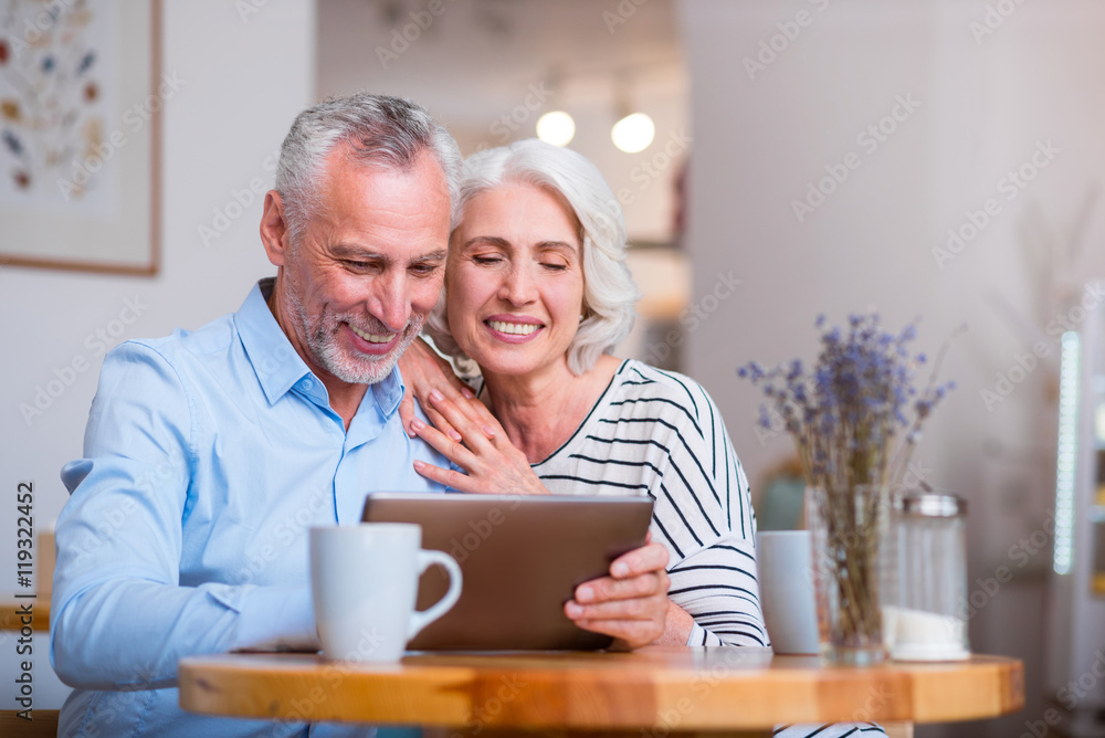 Positive loving couple sitting at the table Positive loving couple sitting at the table