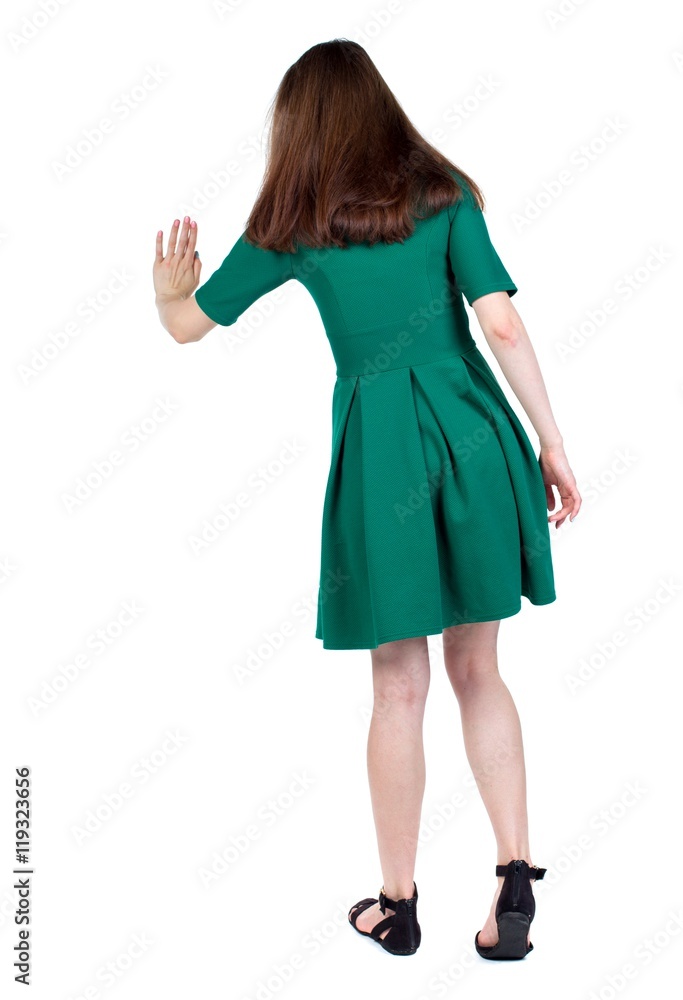 back view of woman. Rear view people collection. backside view of person. The slender brunette in a green short dress presses a button on the hand. back view of woman. Rear view people collection. backside view of person. The slender brunette in a green short dress presses a button on the hand.