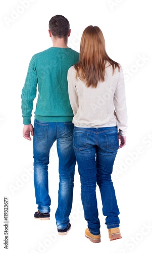 Back view going couple. walking friendly girl and guy holding hands. Isolated over white background. Couple in warm jackets out into the distance.