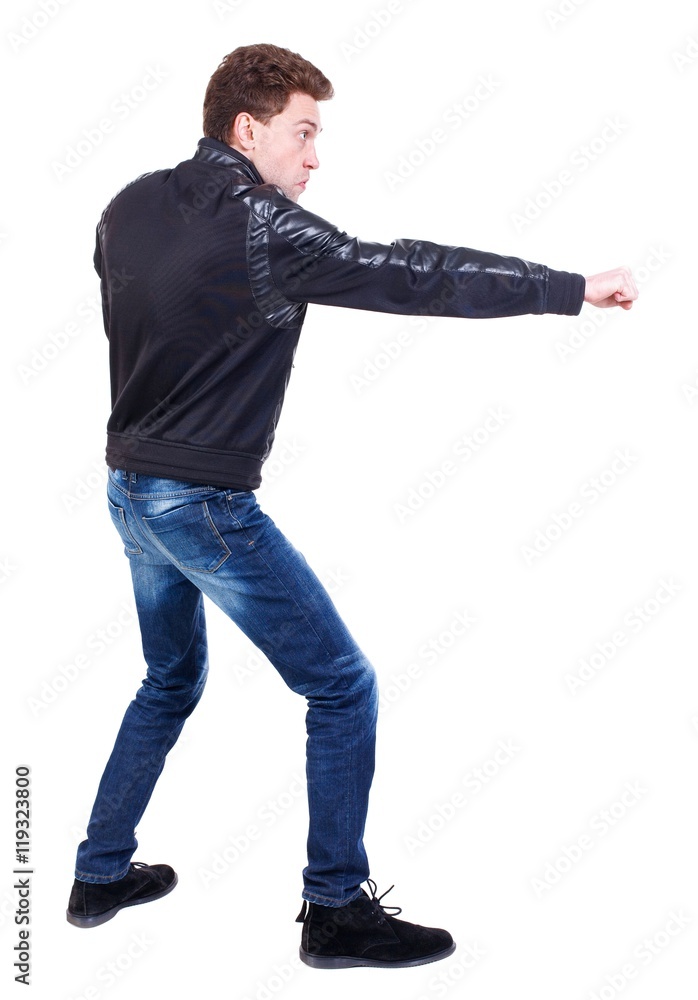 back view of guy funny fights waving his arms and legs. Curly guy in a black leather jacket fun waving his arms. back view of guy funny fights waving his arms and legs. Curly guy in a black leather jacket fun waving his arms.