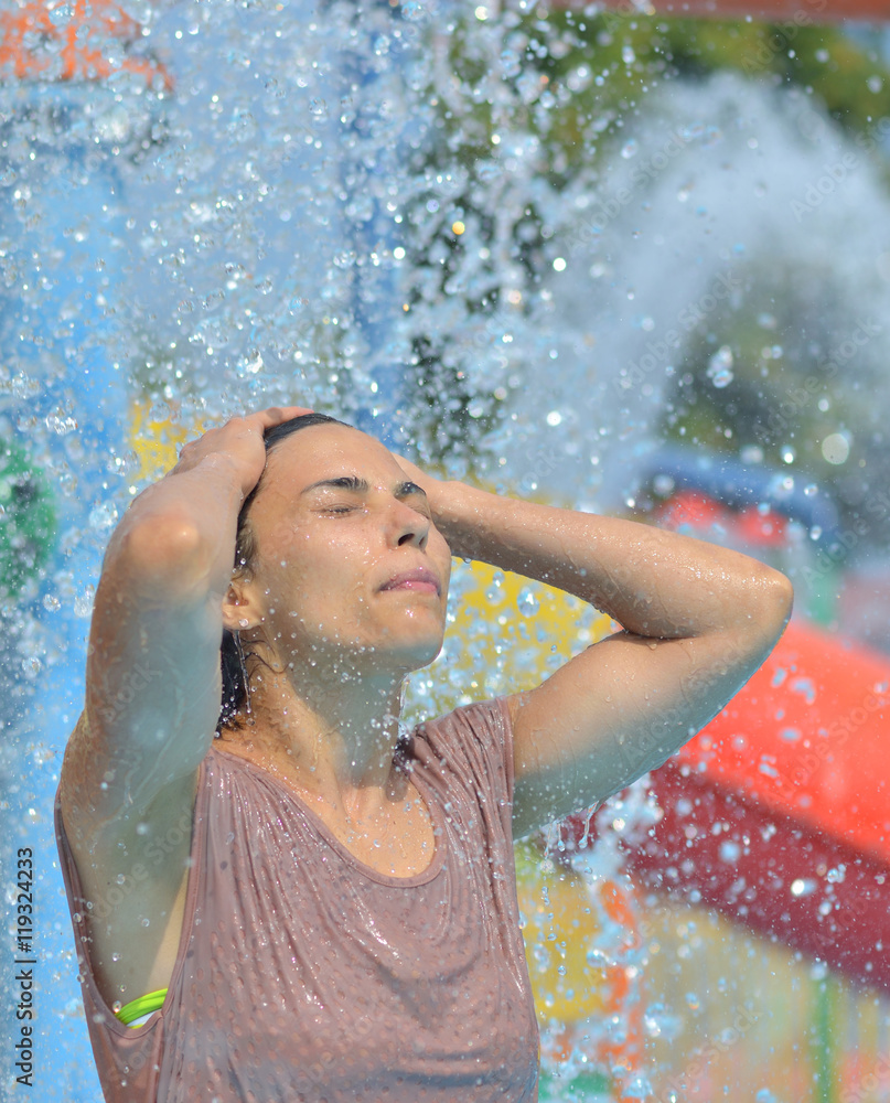 Obraz premium Beautiful woman enjoying under a water jet with thousands of drops in the background