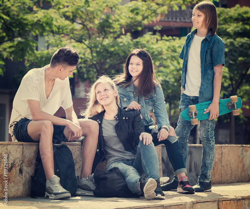 Group of smiling teenagers in park on summer day