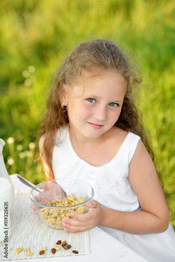 Close up portrait of adorable girl having breakfast and drinking milk outdoor. Cereal, healthy lifestyle Close up portrait of adorable girl having breakfast and drinking milk outdoor. Cereal, healthy lifestyle