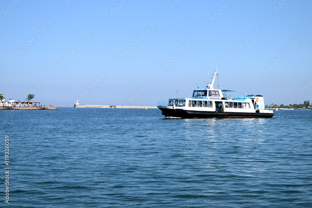 SEVASTOPOL, RUSSIA - JULE 12.2016: pleasure boat sails near the waterfront SEVASTOPOL, RUSSIA - JULE 12.2016: pleasure boat sails near the waterfront