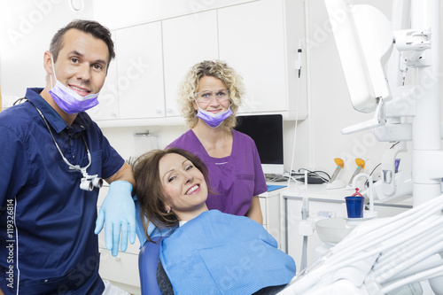 Patient With Dentist And Assistant At Clinic