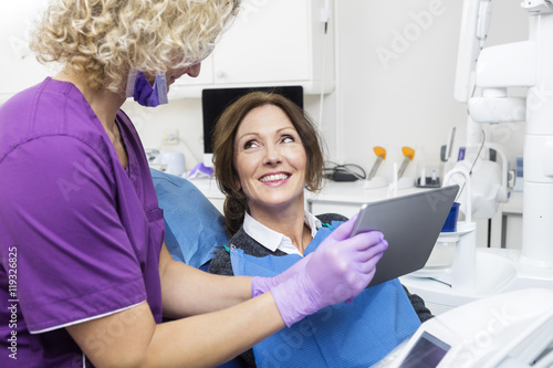 Assistant Showing Report To Happy Patient On Digital Tablet photo