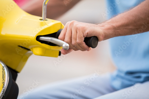 Hand on scooter's steering wheel. Hand of adult man. Travel fast with comfort. Push on gas.