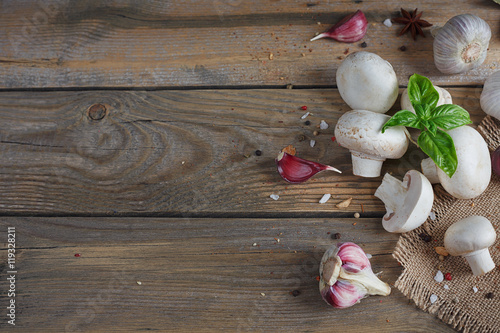Fresh mushrooms and garlic on wooden background