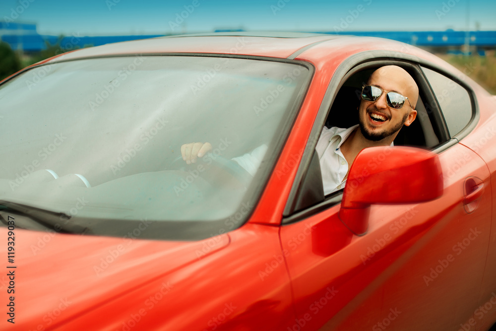 happy man sriving a red sport car