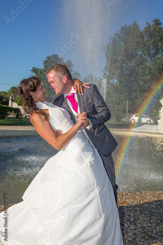 Carta da parati kiss of bride and groom near the fountain rainbow