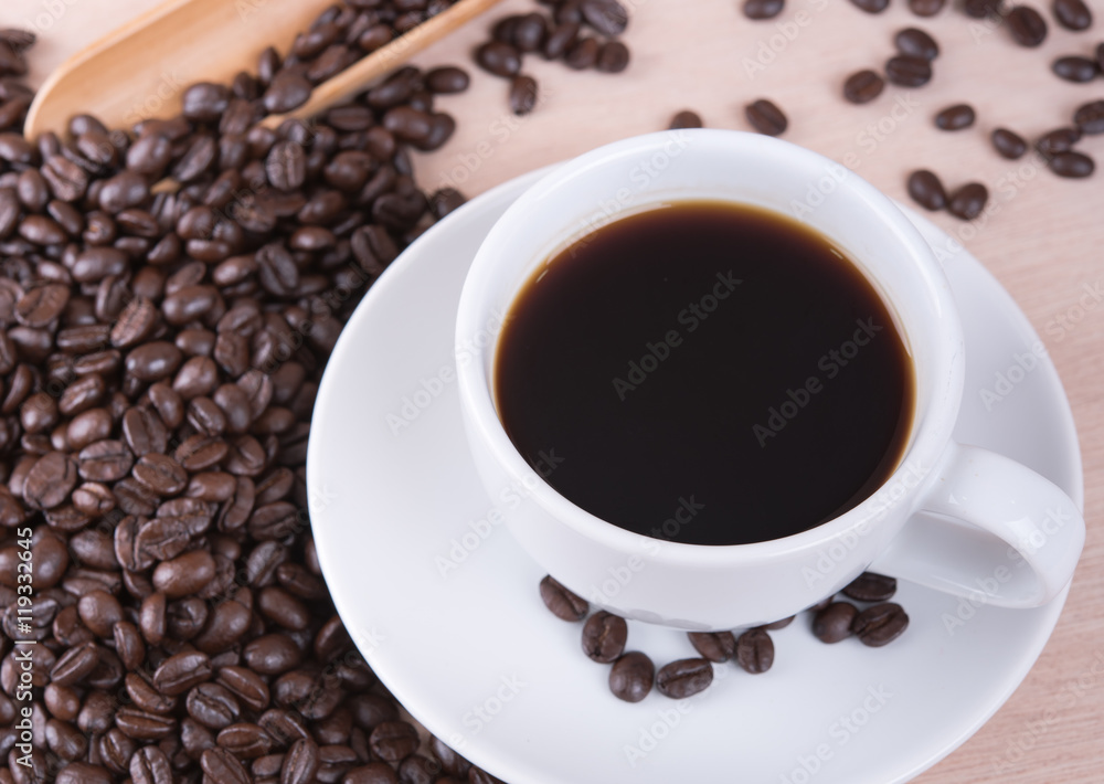 Coffee cup and coffee beans on wood table in coffee shop Coffee cup and coffee beans on wood table in coffee shop