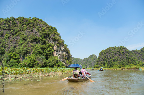 Tourists asia traveling in boat along nature the river and mountain at vietnam