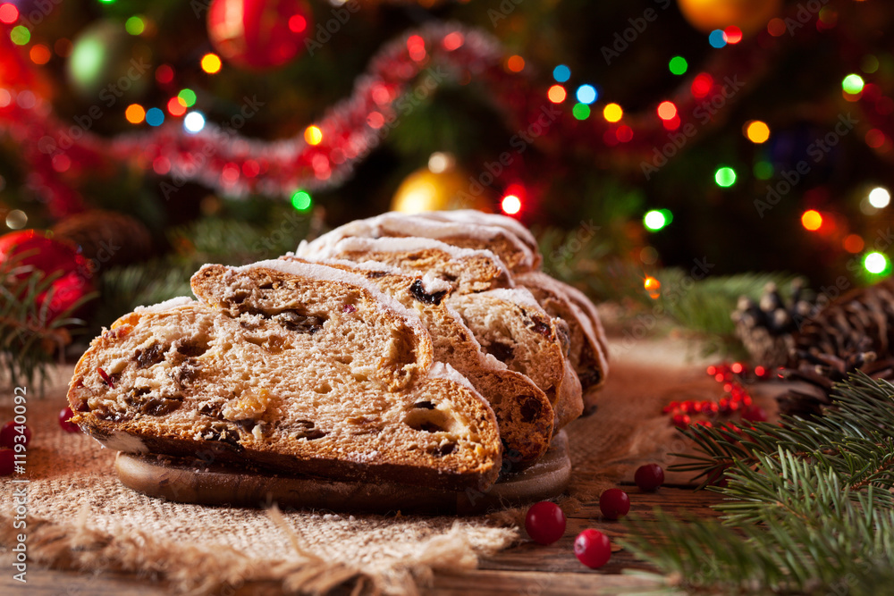 Traditional Dresdner German Christmas cake Stollen with Marzipan, Berries Nuts, Cinnamon, Raising on a rustic wooden festive table. Holiday xmas celebration decorations. Traditional Dresdner German Christmas cake Stollen with Marzipan, Berries Nuts, Cinnamon, Raising on a rustic wooden festive table. Holiday xmas celebration decorations.